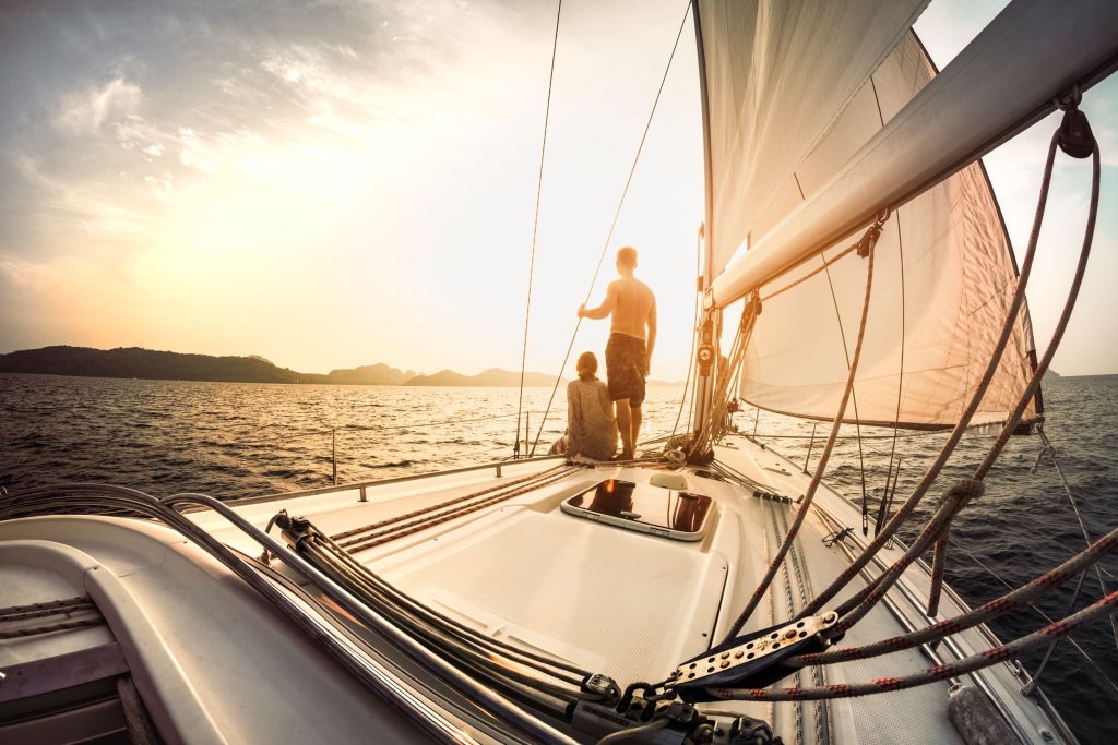 Paar auf einem Segelboot schaut sich den Sonnenuntergang an