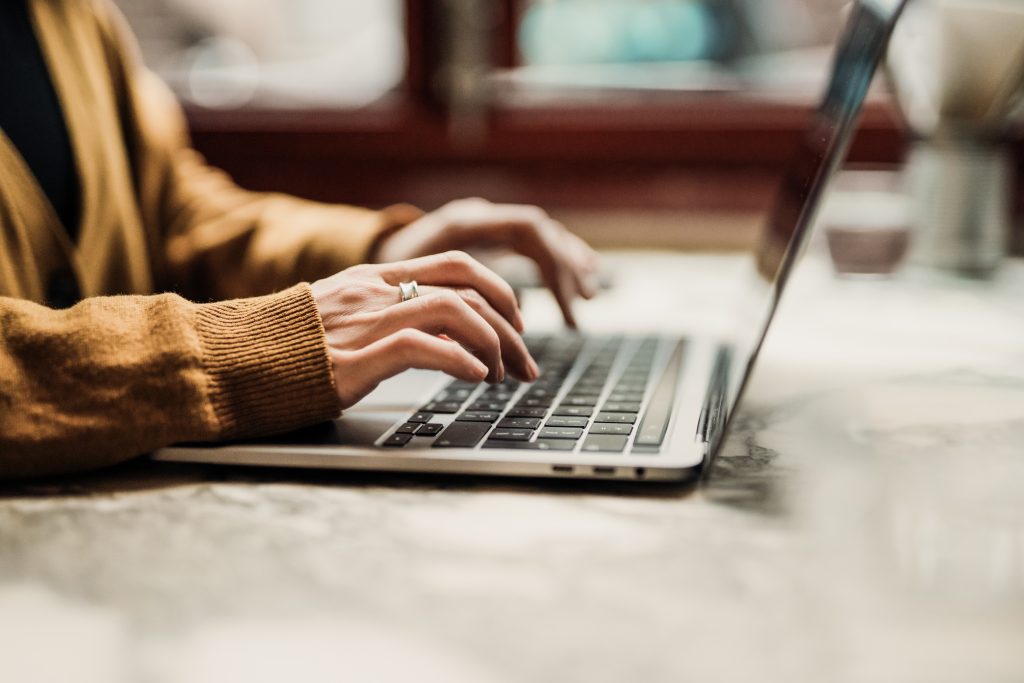 Nahaufnahme einer nicht erkennbaren Frau mit Laptop