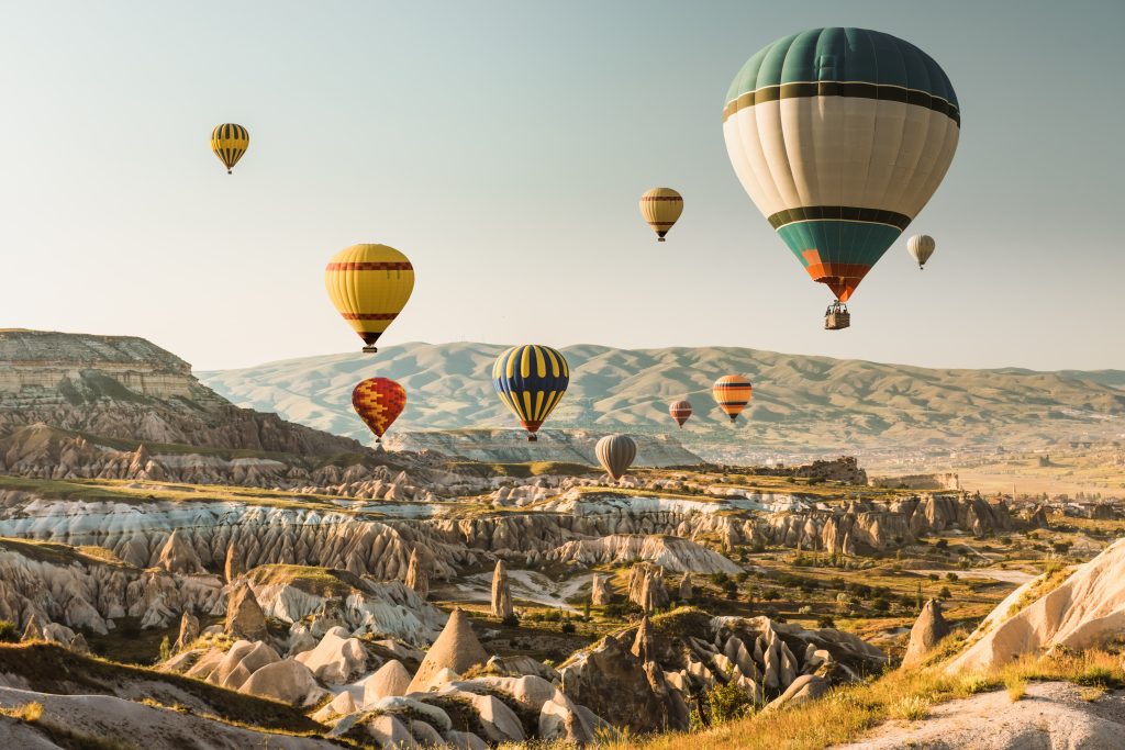 Heißluftballons fliegen beim Sonnenaufgang über Kappadokien, Türkei